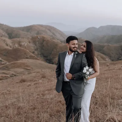 A stunning portrait set against the rolling hills. The couple's classic attire contrasts beautifully with the wild, untamed landscape, creating a timeless and romantic image.