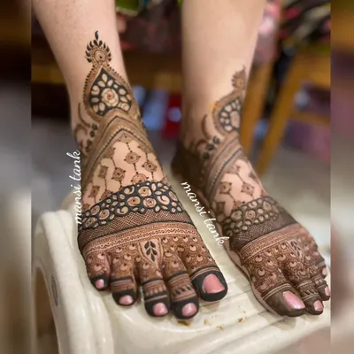 This is a full coverage bridal foot mehendi. The intricate design flows from the toes all the way up past the ankle, creating a stunning look that is perfect for a bride.