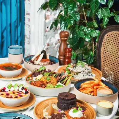A bright and inviting brunch spread, perfect for a modern cafe. We styled this table with a variety of dishes, from savory bowls to decadent desserts, creating a vibrant and appealing scene that showcases the breadth of the menu against a fresh, leafy backdrop.