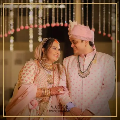 A beautiful moment between the happy couple. Our groom Mihir wears a custom-designed pink printed sherwani that perfectly complements the bride's attire and the wedding's color palette.