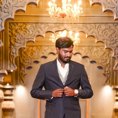 A handsome portrait of the groom-to-be, looking sharp in his suit. The grand, warmly lit hall provides an elegant backdrop for this solo shot.