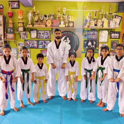 A group of our young Taekwondo students with their coach. We are proud of our growing team.