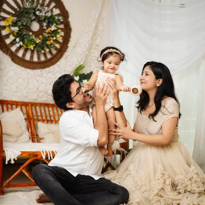 A beautiful family portrait, with mom and dad lifting their little girl up in a moment of pure joy. These are the candid, love-filled shots that become treasured heirlooms.