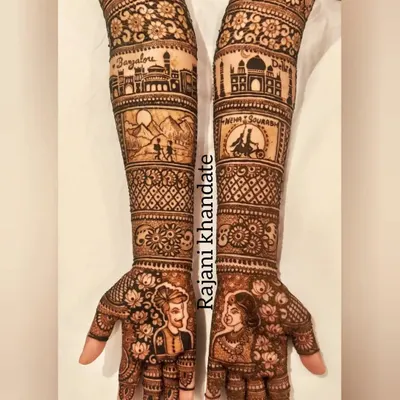 This bridal design tells a complete love story, from the couple's portraits on the palms to their shared memories on the arms. One arm features the Bangalore skyline, while the other shows a trekking scene and a depiction of their time in Delhi.