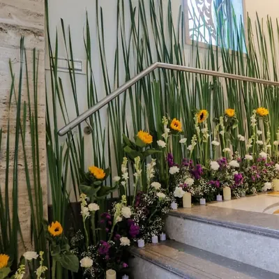 An office entrance or staircase is the perfect canvas for making a first impression. For this corporate space, I designed a modern and elegant floral runner using tall grasses for height, accented with bright sunflowers, white tuberoses, and purple statice to add color and life.