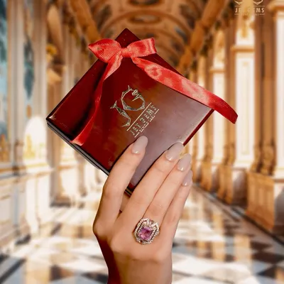 The feeling of pure luxury. This image captures the moment of receiving a special gift, with a stunning pink gemstone ring on hand, ready to be treasured. The perfect gift for an unforgettable presence.