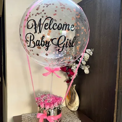 Our signature hot air balloon floral arrangement is the cutest way to say 'Welcome Baby Girl'. We fill a luxe silver box with fresh pink roses and baby's breath, then top it with a custom confetti balloon to make the celebration extra special.