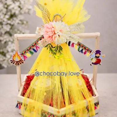 This bright yellow Lohri hamper is designed to capture the festive spirit. Wrapped in vibrant net and decorated with traditional motifs, it's filled with festive favorites and is perfect for family, friends, or corporate gifting.