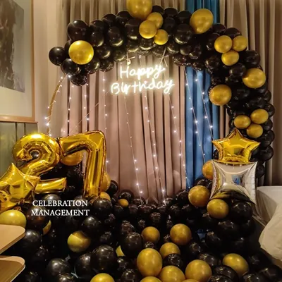 A classic and bold choice for a 27th birthday. This circular balloon arch in black and gold is paired with a 'Happy Birthday' neon sign for a sophisticated party look.