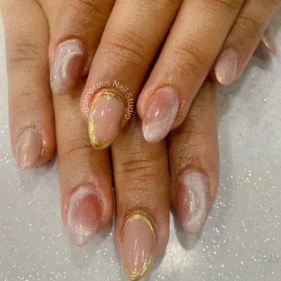 The epitome of elegance. This minimalist design features a sheer nude base with a soft, white ombre effect and a delicate gold chrome outline on the accent nails.