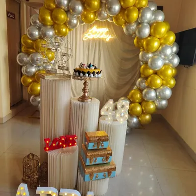 For this 48th birthday, I created a classy gold and silver balloon arch to frame the celebration space. The setup features custom marquee letters spelling "APPA", light-up numbers for the age, and a "Happy Birthday" neon sign, all brought together with decorative pedestals and props.