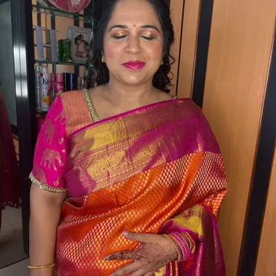 A close-up of Dipti's makeup. The gold shimmer on the eyes and the bright pink lip create a festive and joyful look.