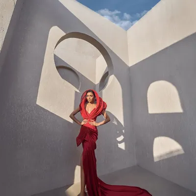 Step into a world of bold elegance with this structured red hooded gown. The rich fabric creates an aura of power, while the meticulously crafted hood adds an edgy, modern twist.