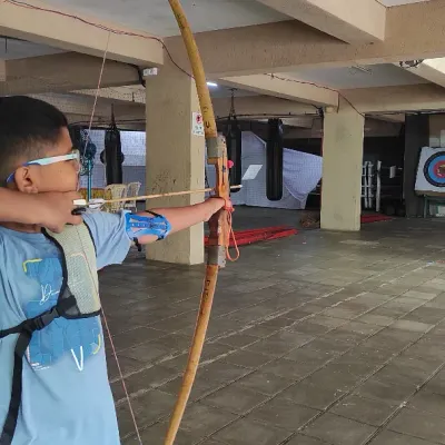 A young archer focuses on his form during a basic course session. We emphasize proper technique with our recurve bows to build a solid foundation for every student.