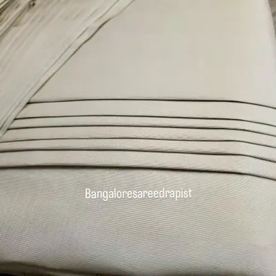 A close-up of the neat lines on a box-folded engagement saree. This compact fold protects the delicate fabric and ensures the pleats remain crisp during transport.