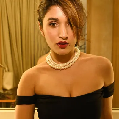 A modern take on classic beauty. This look, with its bold lip, simple eye, and pearl necklace, is perfect for a sophisticated evening event or a commercial shoot.