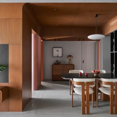 This dining area is designed as the apartment's centerpiece, featuring a wooden ceiling and Pamplona chairs. The space seamlessly connects different areas, fostering a sense of flow and continuity.