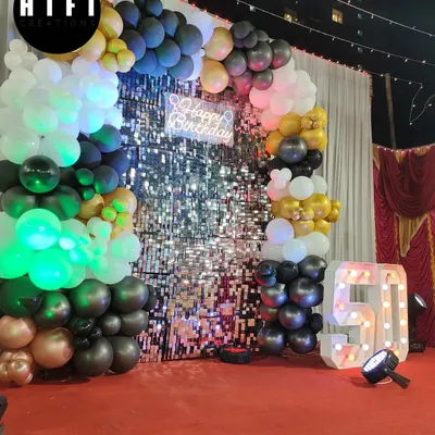 A glamorous 50th birthday celebration with a black, gold, and white theme. The decor features a stunning sequin wall and a large light-up number '50'.