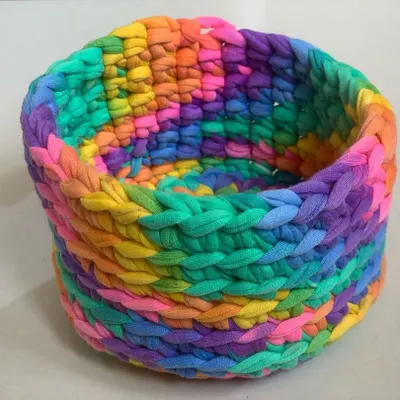 This colorful rainbow basket is made with a thick, chunky yarn, making it sturdy and durable. It's perfect for adding a pop of color and a bit of organization to your desk or dresser.