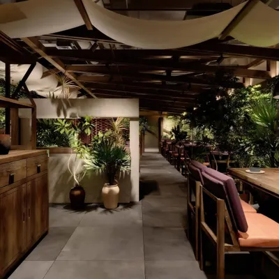 A work-in-progress render of a restaurant with a rustic, biophilic design. The visualization explores the interplay of raw wood, concrete, and abundant greenery.
