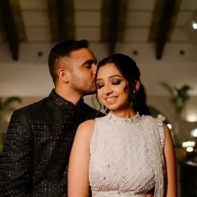 An intimate and romantic portrait of the groom kissing his bride's forehead during their Sangeet night, a quiet moment amidst the celebration.
