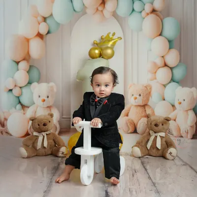 This little gentleman is ready to ride into his first year. The classic setup with pastel balloons, teddy bears, and a toy tricycle creates a timeless first birthday portrait.