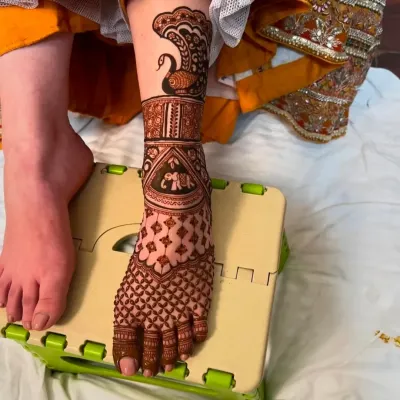 A beautiful design for the foot, featuring a peacock on the ankle and an elephant motif below it.
