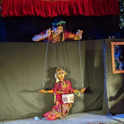 A puppeteer skillfully manipulates a string puppet from above the stage. This view shows the technique and focus required to make the puppet dance and express emotion, bringing the character to life for the audience below.