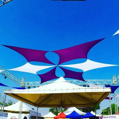This is how I transform an open field into a vibrant festival space. This custom fabric canopy installation in Pune provided both shade and a stunning visual centerpiece for the Times Now food festival, using a dynamic pattern of purple and white sails against the sky.