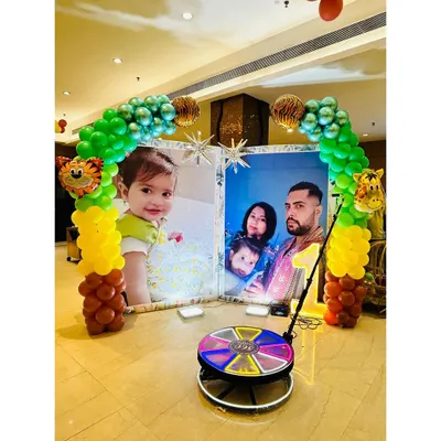 A clear view of the 360-degree video booth, set up in front of a personalized photo backdrop. It's a fantastic way for guests to capture fun, memorable videos.