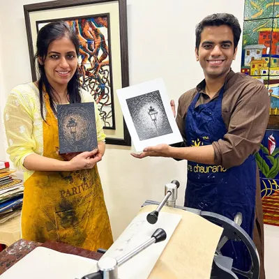 A student proudly displays their finished linocut print next to the carved block. Our workshops are led by expert printmakers like Tarun Sharma.