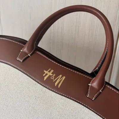 A close-up of the H&M logo I hand-painted on a tote bag's leather strap. Paint pen calligraphy requires a steady hand and patience, but the result is a beautifully customized piece that reflects your style.