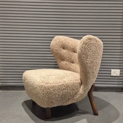 This is one of my favourite designs, a lounge chair upholstered in a beautiful bouclé fabric. The unique, sculptural form and solid wood legs make it a true statement piece for any living room or building lobby.