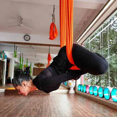 A student practices an inversion in an aerial yoga hammock. This practice, also known as anti-gravity yoga, helps to decompress the spine and build upper body strength in a fun, new way.