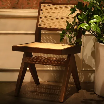 This chair is a modern interpretation of a classic design, featuring a solid wood frame with woven cane detailing on the seat and back. It’s a piece that is both lightweight and sturdy, bringing an element of natural, handcrafted beauty to any room.