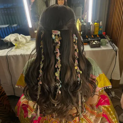 A truly unique and beautiful hairstyle for the modern bride. This look features soft waves with delicate, ribbon-like accessories woven through for a flowy and stunning effect.