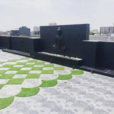 This is a wider view of the serene terrace project, showing how the Buddha water feature, checkerboard flooring, and low boundary walls come together to create a spacious and peaceful rooftop environment.