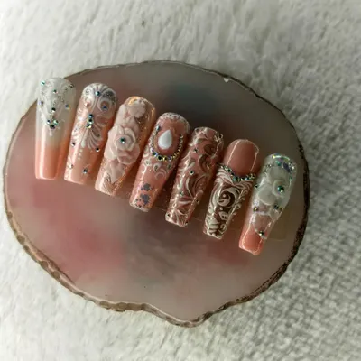 Here is another angle of our intricate bridal-style nail art. In our advanced classes, you will learn the layering techniques required to create these detailed 3D floral patterns and delicate white accents.