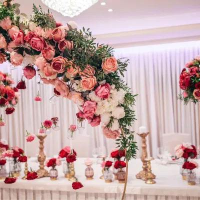 We create breathtaking floral designs that serve as the centerpiece of your event's decor. This elaborate floral arch over a head table, with cascading flowers and elegant candle holders, is an example of the sophisticated ambiance we can bring to a corporate dinner or gala.