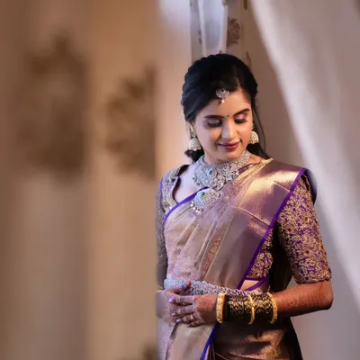 A soft and elegant reception look. This bride is wearing a beautiful purple and gold saree, and her makeup is subtle yet glamorous, with shimmery eyeshadow and diamond jewellery.