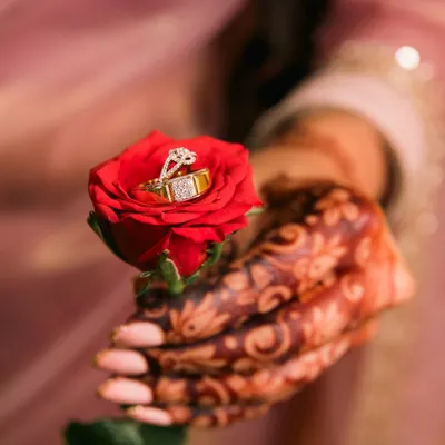 A creative and romantic shot of the engagement rings placed inside a vibrant red rose. We love finding unique ways to photograph these important symbols of your commitment.