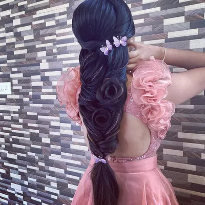An advanced, sculptural braid featuring multiple rose shapes woven into the plait, accented with delicate butterfly clips. This hairstyle is a true demonstration of artistic skill.