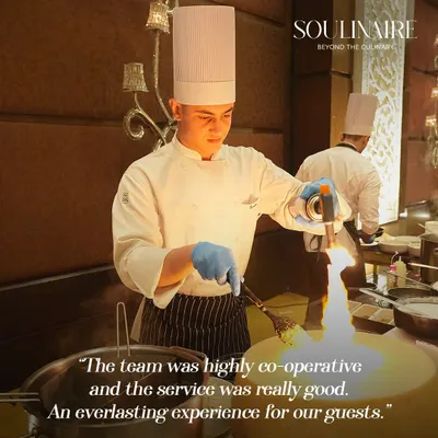 A chef uses a blowtorch to add the finishing touch to a dish, creating a dramatic flair at a live station. This is where flavour meets finesse and food becomes a performance.