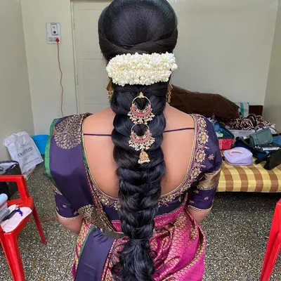 A beautiful 'Varpooja' look featuring a traditional braid adorned with a jasmine gajra and elegant temple jewellery earrings attached to the hair.