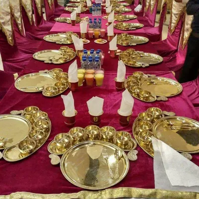 A traditional sit-down dining arrangement with beautiful brass thalis set on a rich velvet tablecloth. This service is perfect for formal family functions and religious ceremonies.