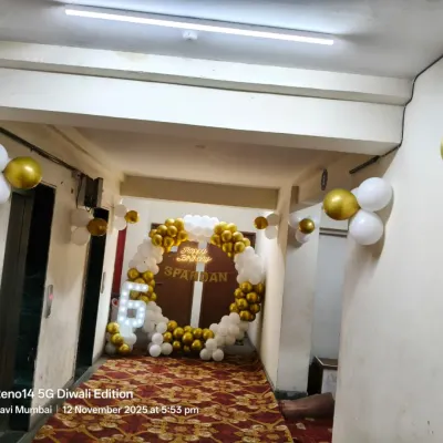 This grand entrance was for a special birthday celebration. I created a circular balloon arch in classic white and gold right in the building's lobby, featuring a light-up marquee letter 'S' and the name 'Spandan' to welcome guests to the party.