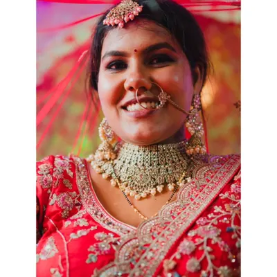 A close-up portrait of a radiant bride, her genuine smile and beautiful jewelry captured in stunning detail. This is a perfect example of a classic, happy bridal shot.