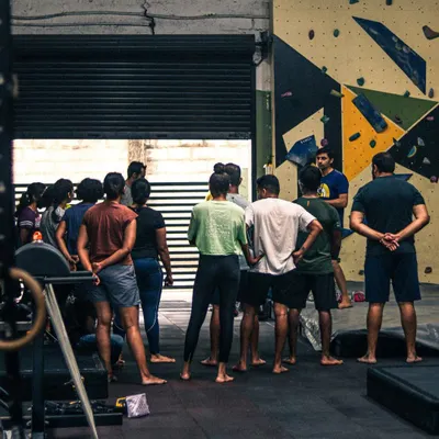 Every workshop starts with a briefing from our experienced instructors. Here, a group of new climbers learns about the day's goals and basic safety before hitting the walls.