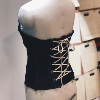 This is the back view of the upcycled denim corset top, showing the lace-up detail. This kind of restyling turns an old shirt or jacket into a completely new, custom-fitted piece.