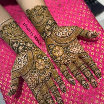 A stunning example of reverse henna technique, where the background is filled to make the floral motifs pop. This creates a bold, dramatic effect that looks amazing in photos.